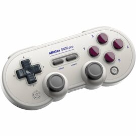 Das Bild zeigt das Gamepad 'SN30 Pro G Classic' von 8BitDo aus einer schrägen Oberansicht. Das Gamepad hat ein klassisches Design mit einem Steuerkreuz links, vier runden Aktionstasten rechts, zwei analogen Sticks unten und Start-/Select-Tasten in der Mitte. Es ist in einem grauen Farbschema mit dunkelvioletten Aktionstasten gehalten, was seinen nostalgischen Stil unterstreicht. Das Bild dient dazu, das Design, die Tastenanordnung und das allgemeine Erscheinungsbild des Gamepads zu präsentieren.